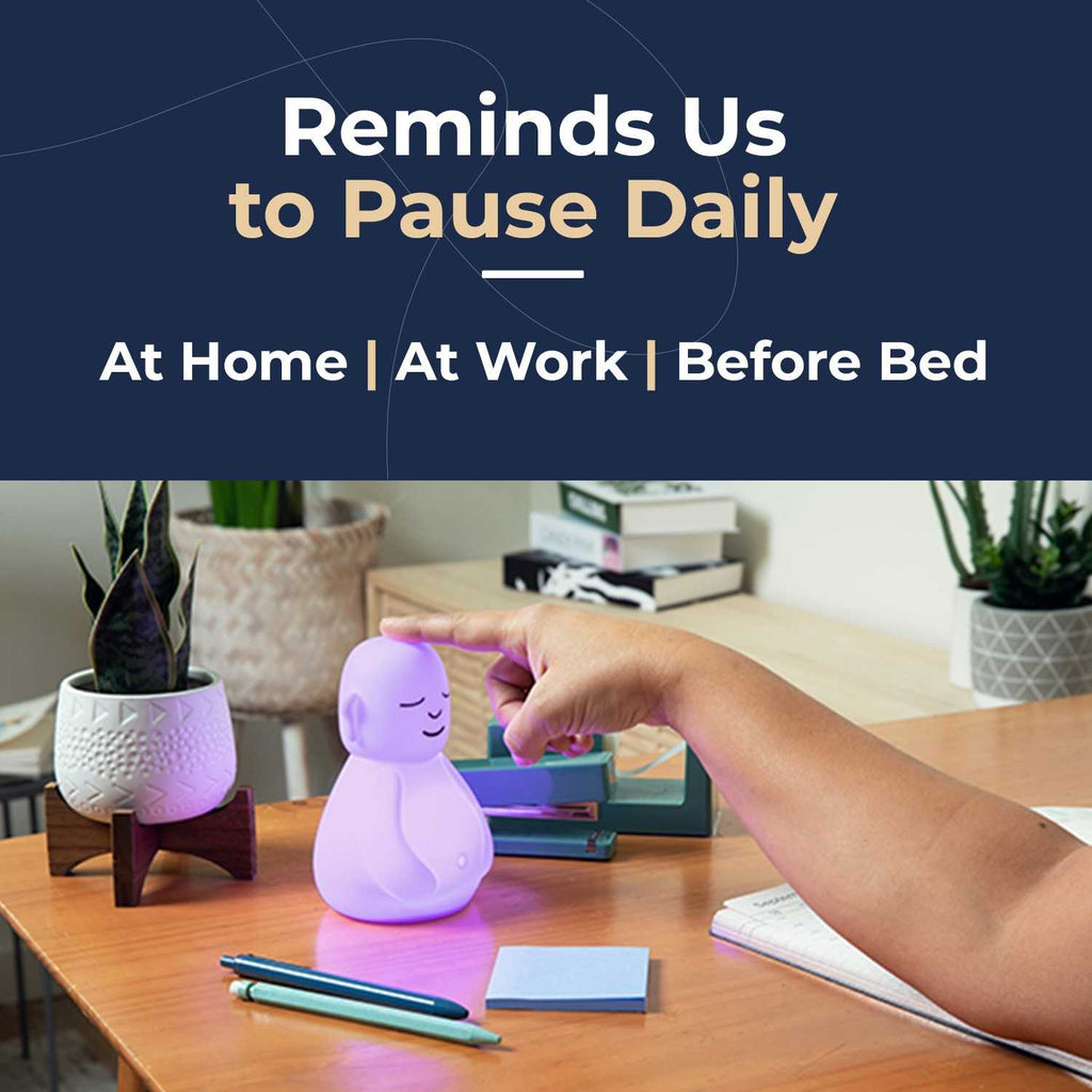 Glowing meditation device on a desk surrounded by plants and stationery, emphasizing daily mindfulness at home, work, or before bed.