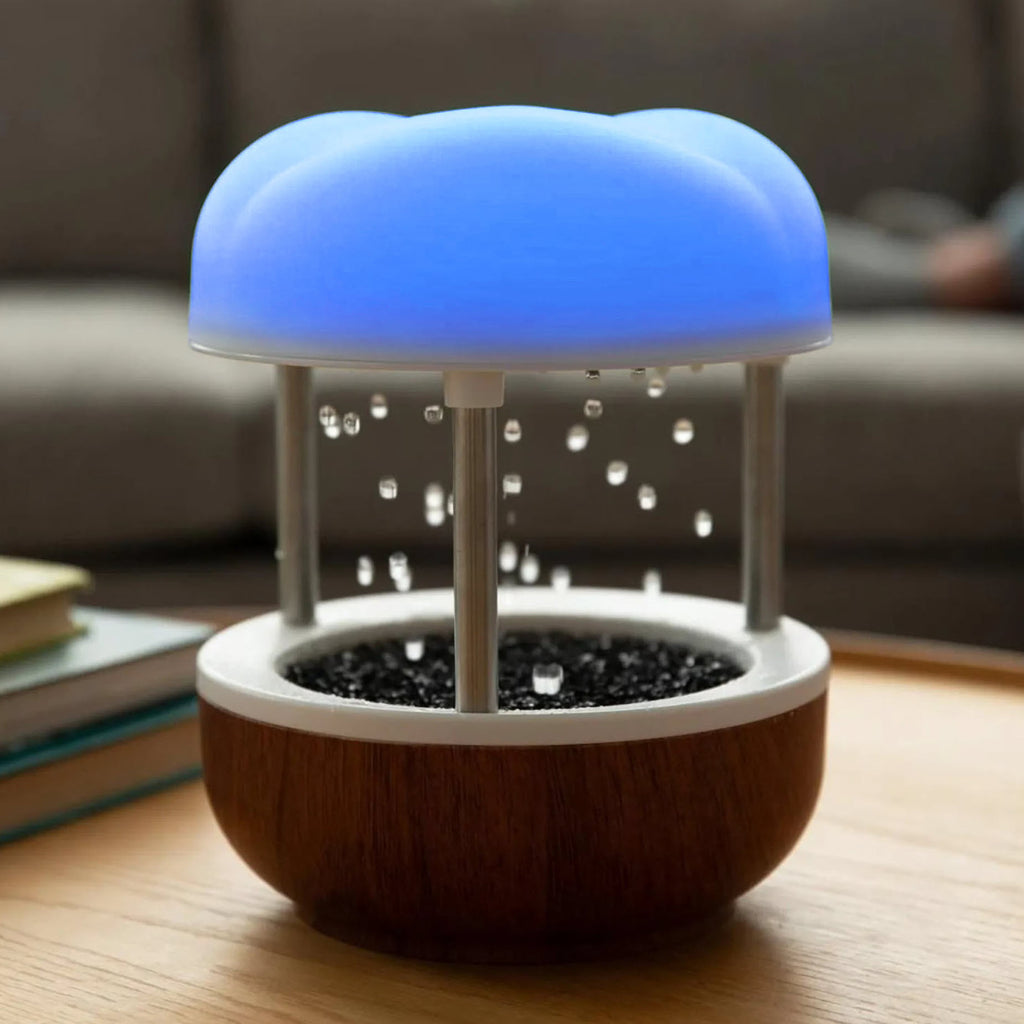 Calming Cloud Fountain with a glowing blue cloud top, water droplets falling into a wooden base, placed on a table indoors.