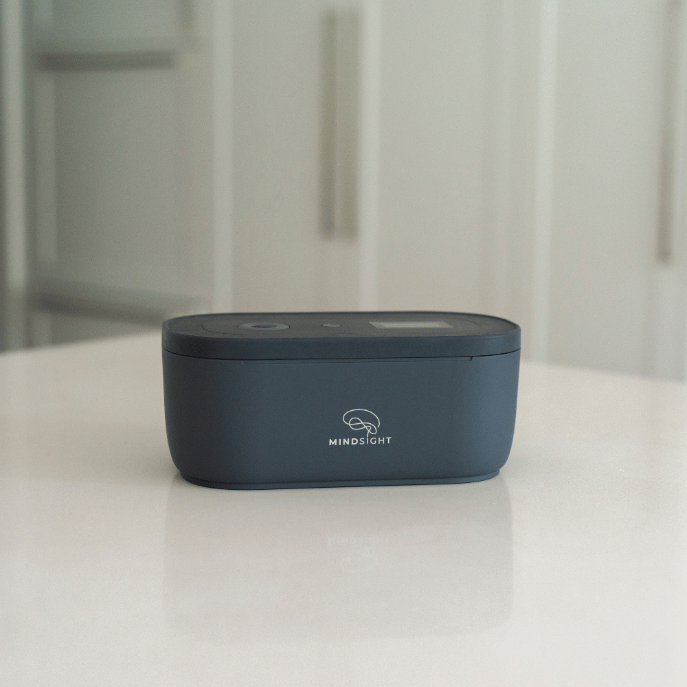 A black Mindsight timed lockbox on a white countertop with a blurred kitchen background.