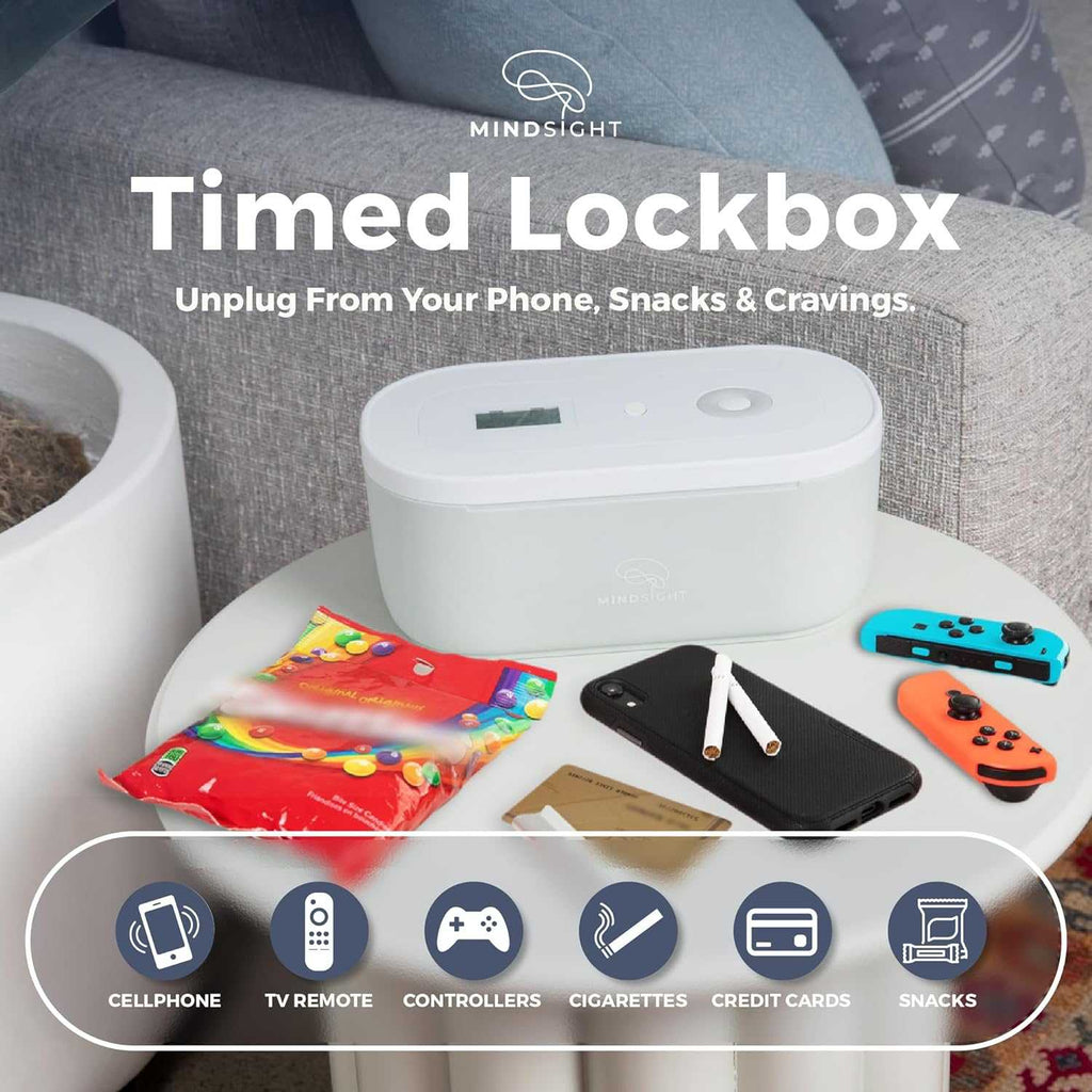 Mindsight Timed Lockbox on a table with snacks, a phone, controllers, and cigarettes, promoting reduced distractions.