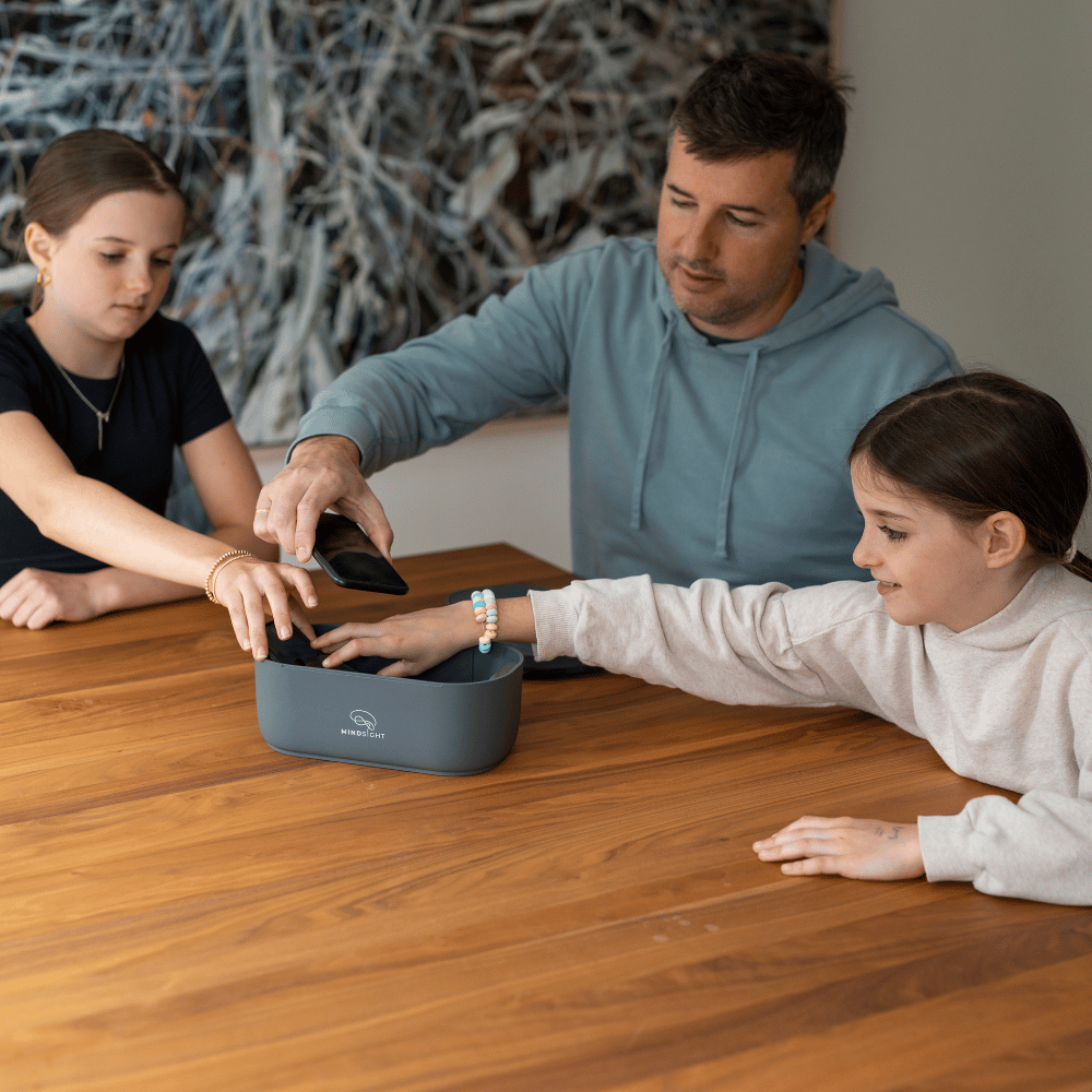 A charcoal mindsight timed lockbox with a digital timer display is surrounded by various items