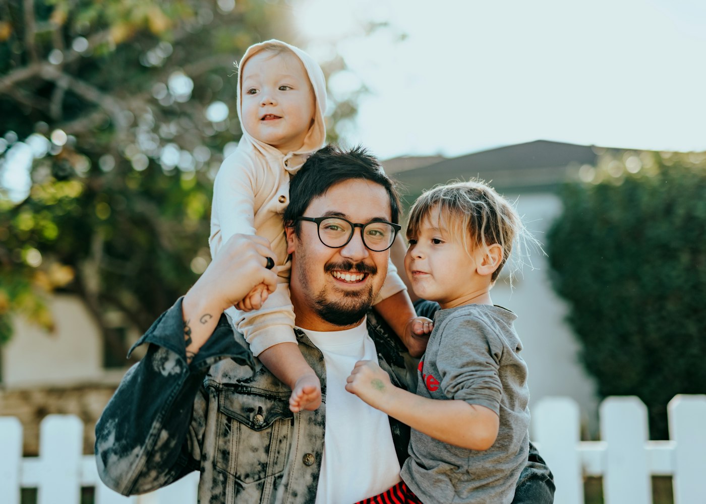 A parent outdoors with two children