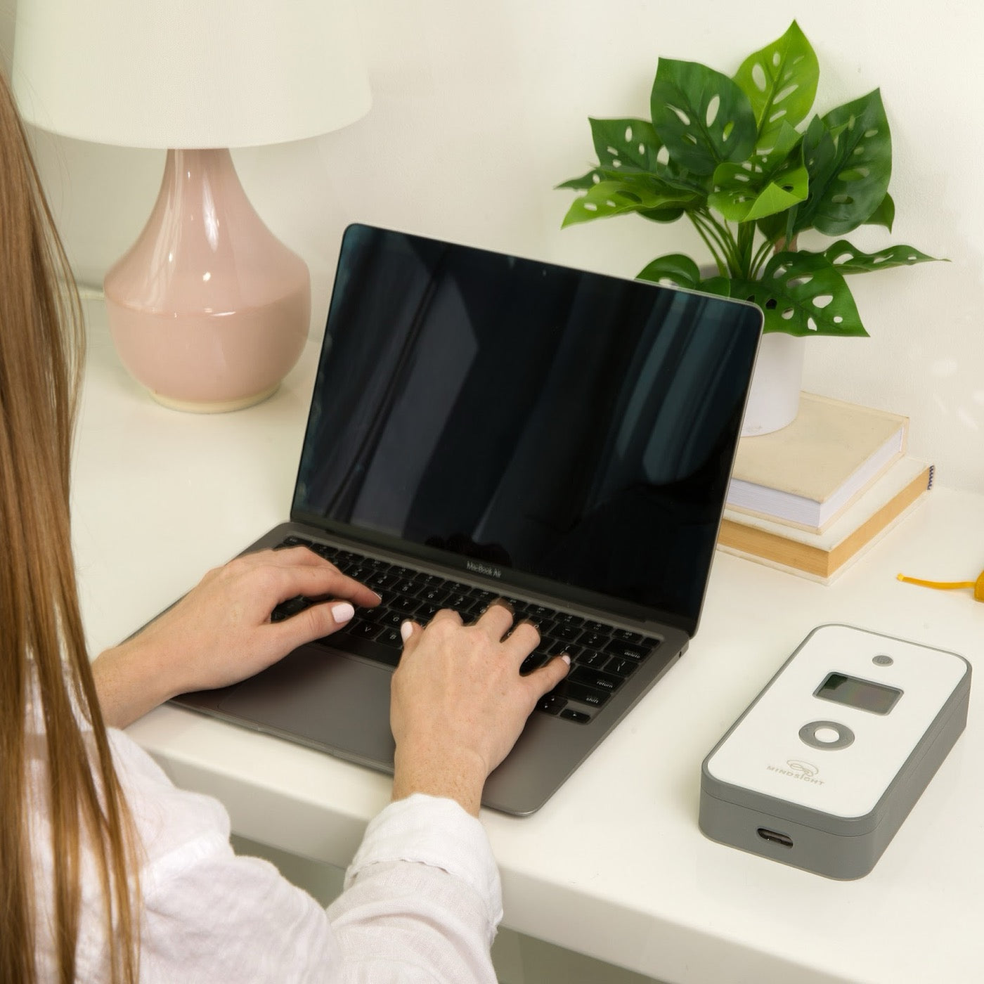A Phone Lock Box on a desk beside a laptop